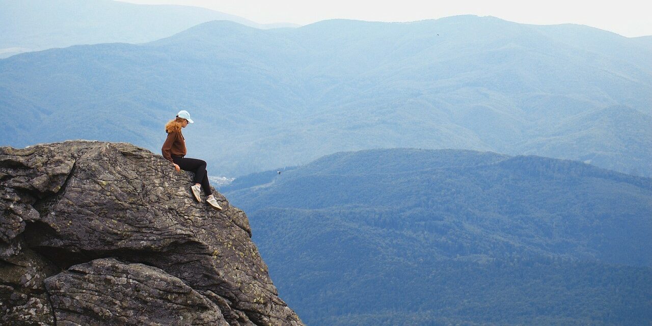 girl sitting on a rock with a view of the blue ridge mountains