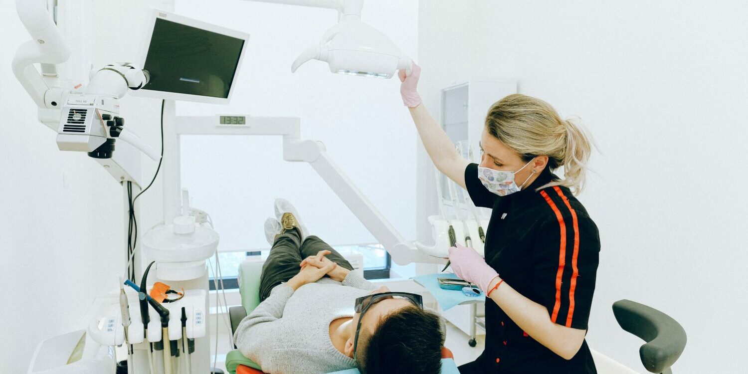 A dentist talks with her dental patient about dental implant cost